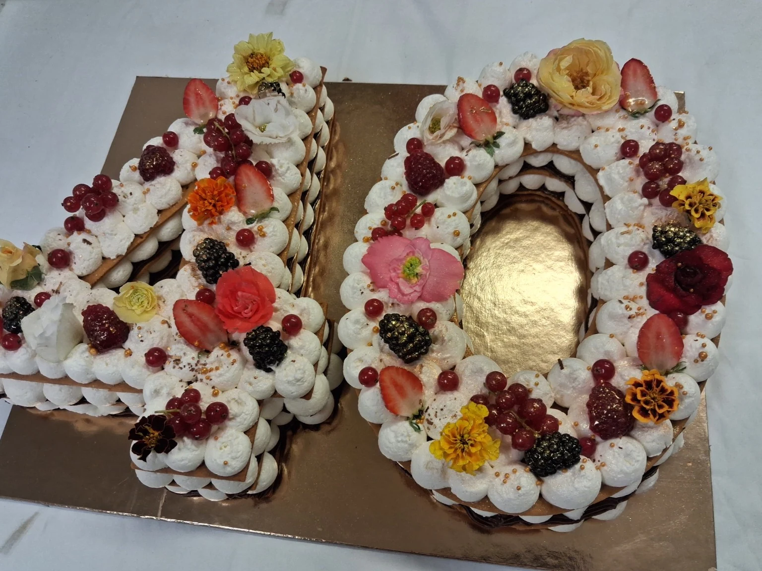 Torta a forma di numero 40 del laboratorio, decorata con frutta e fiori